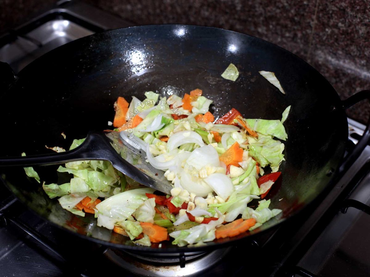 Stir frying vegetables in carbon steel wok