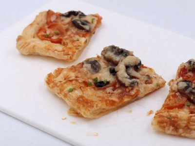 Cheese and mushroom puff pastry tart cut into squares