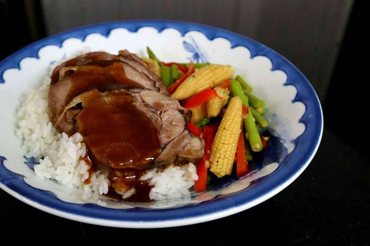 Sliced pork tongue and vegetables over rice