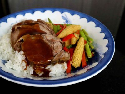 Sliced pork tongue and vegetables over rice