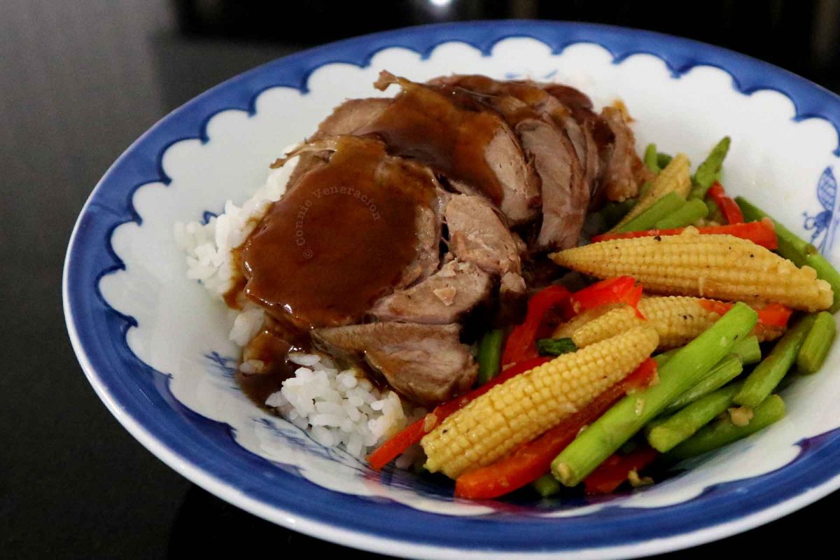 Filipino pork tongue asado in bowl with vegetables over rice