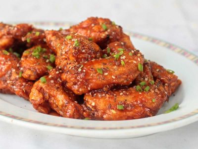 Spicy fried chicken wings on serving plate