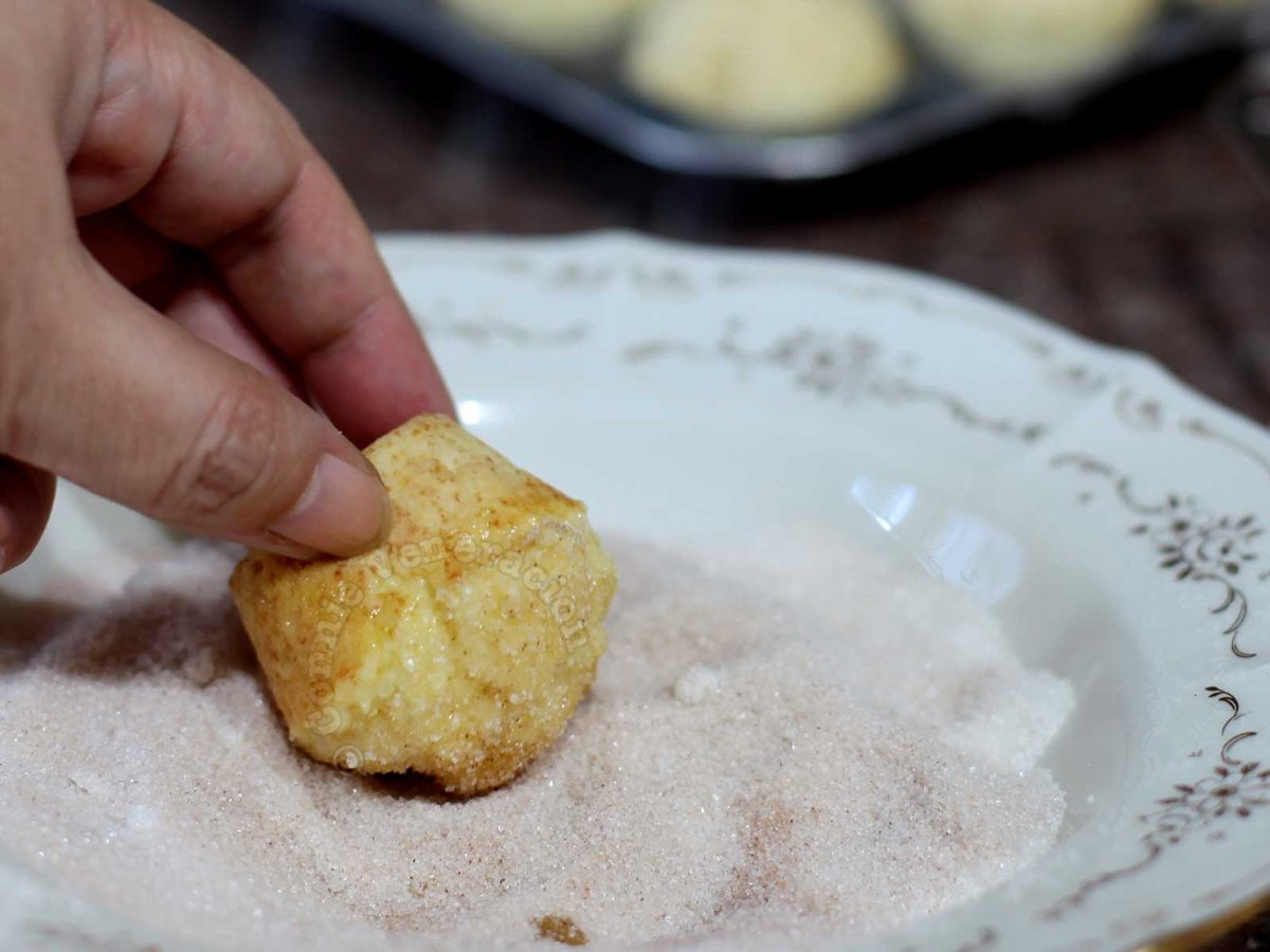 Dipping buttered muffins in cinnamon sugar