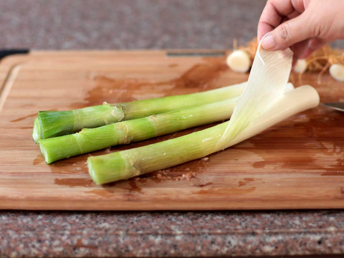 Pulling off the fibrous inedible outer skin of leeks