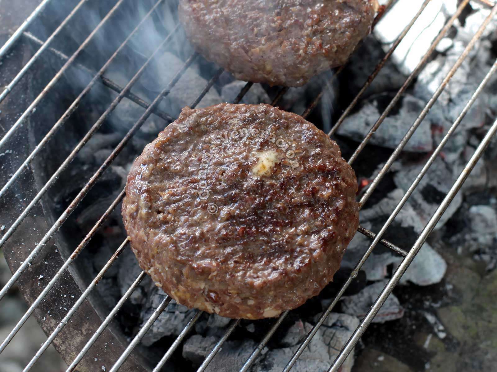Grilling burgers over charcoal