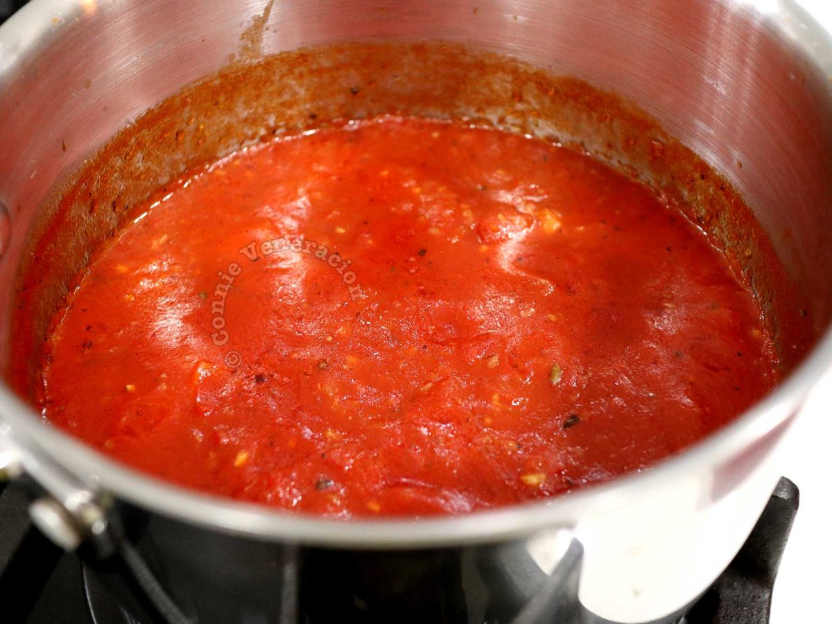 Adding paprika to homemade tomato sauce for a deeper red color (and added flavor too!)