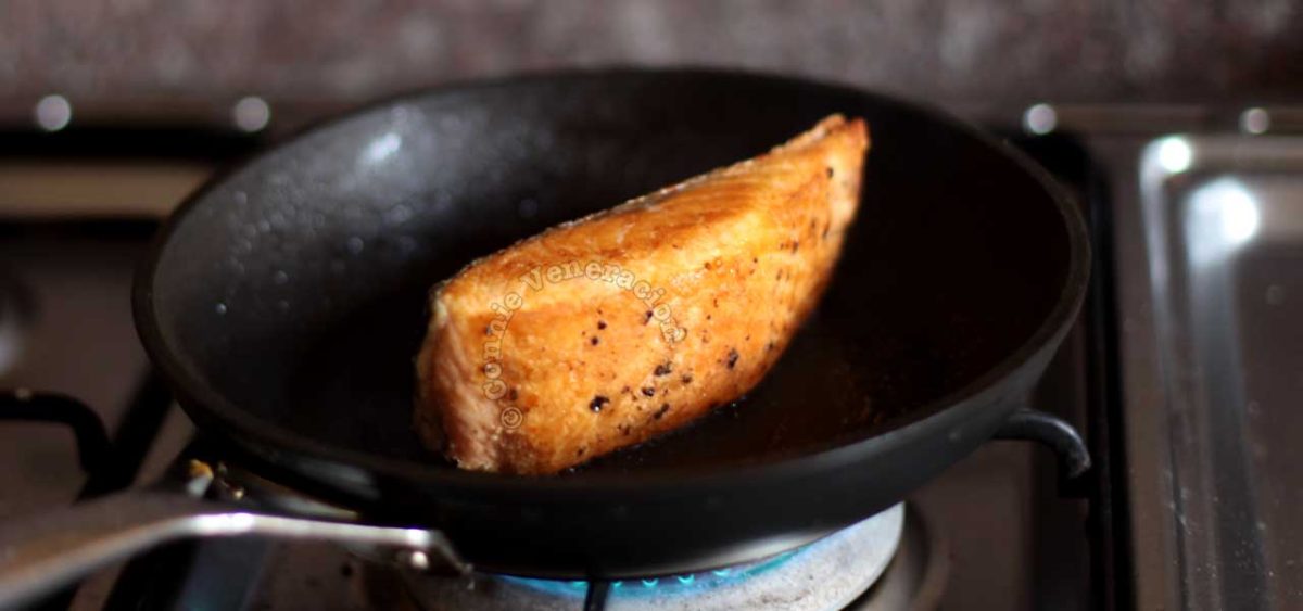 Searing the sides of a salmon fillet in a frying pan