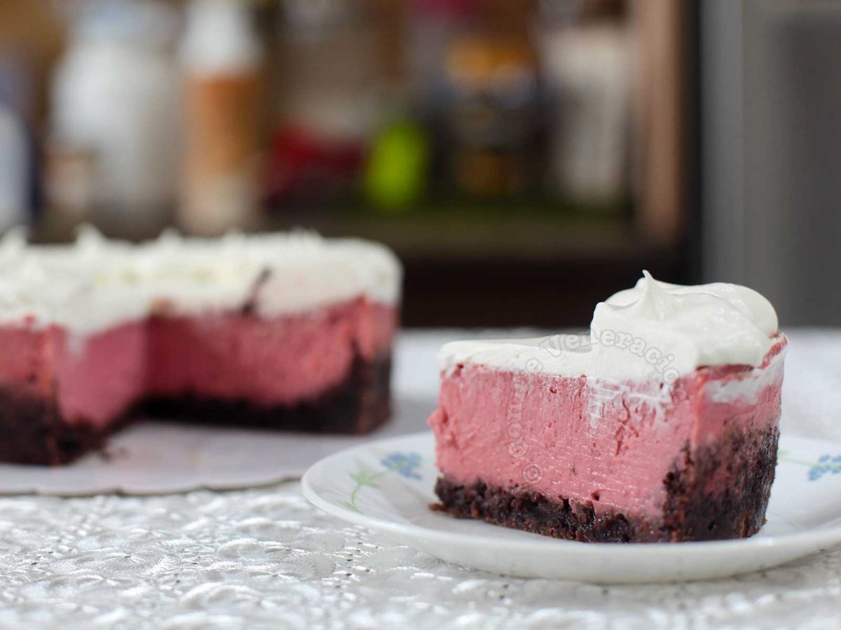 A Slice of Strawberry Cheesecake with Brownie Crust Topped with Whipped Cream