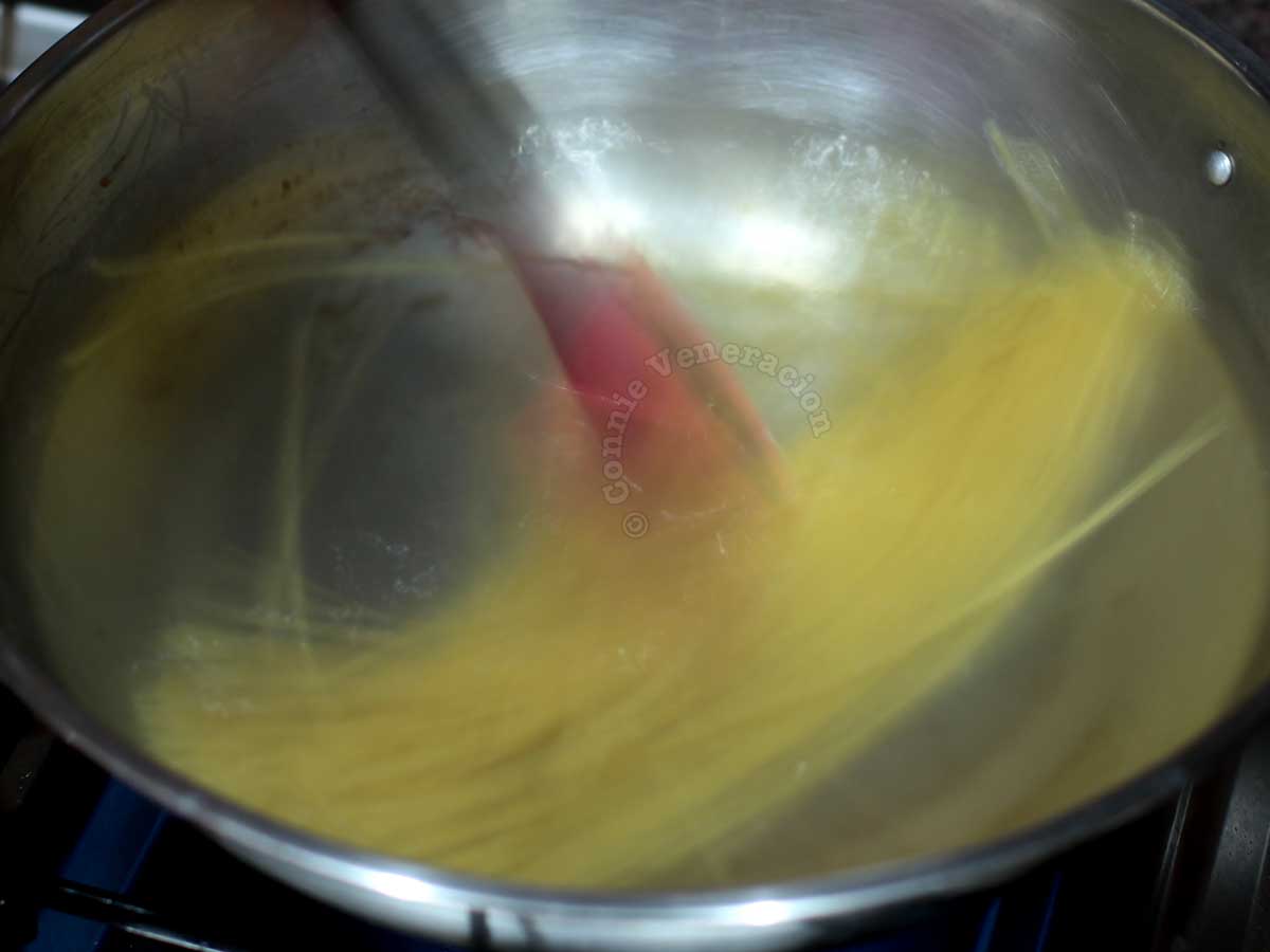 Stirring pasta in pan