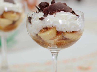 Banoffee in wineglass topped with shaved dark chocolate