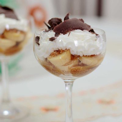 Banoffee in wineglass topped with shaved dark chocolate