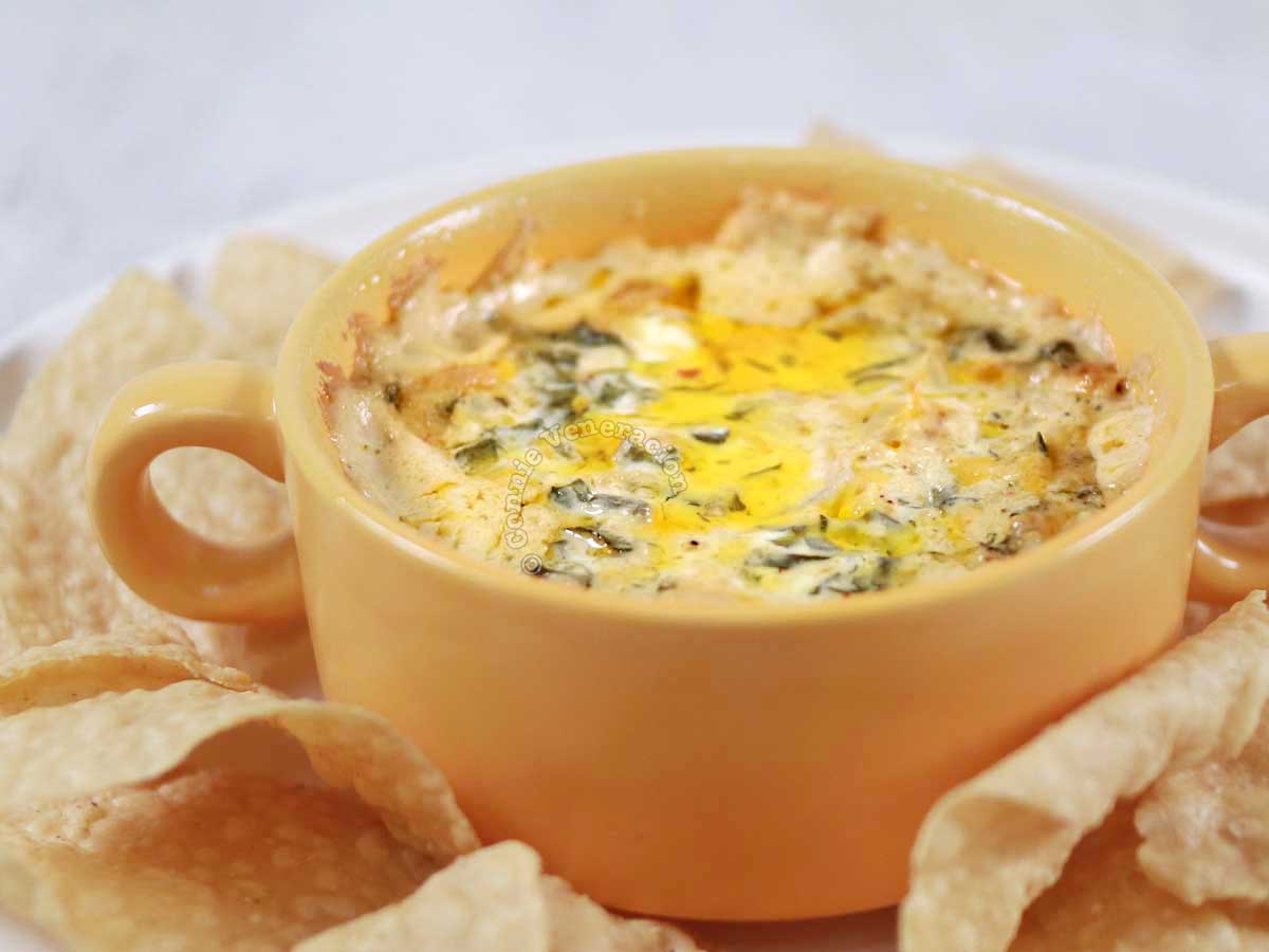 Spinach artichoke dip surrounded by tortilla chips
