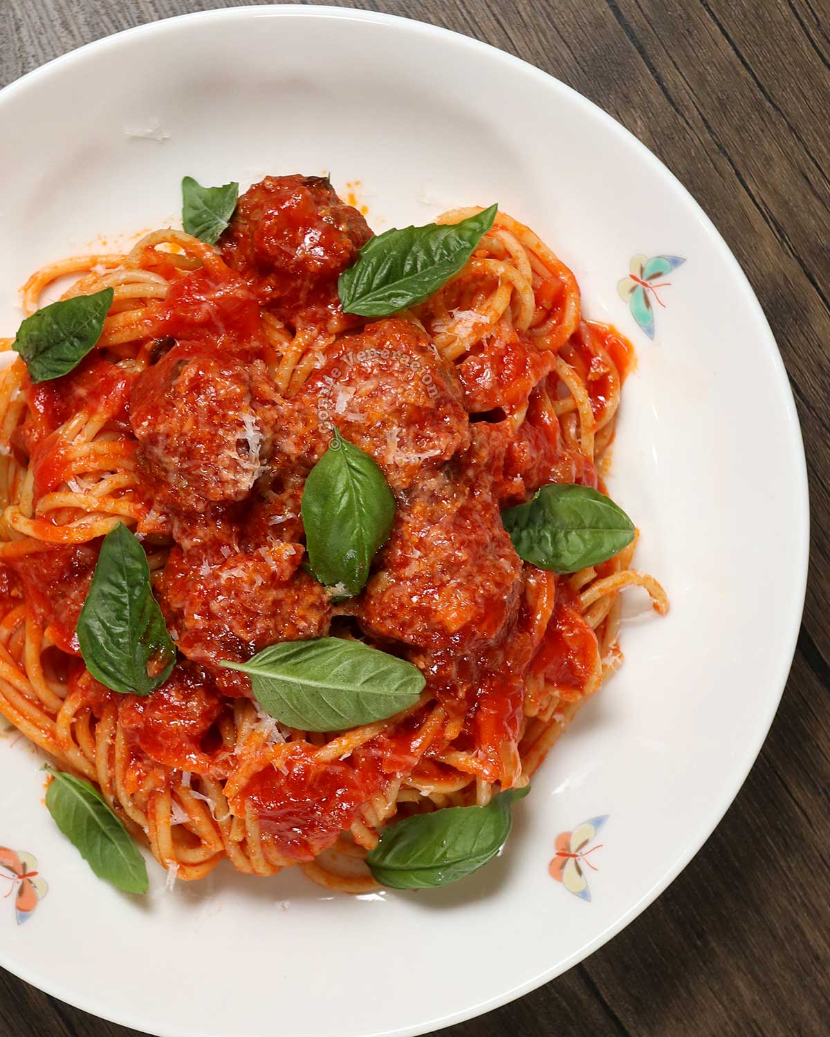 Spaghetti and meatballs in white shallow bowl
