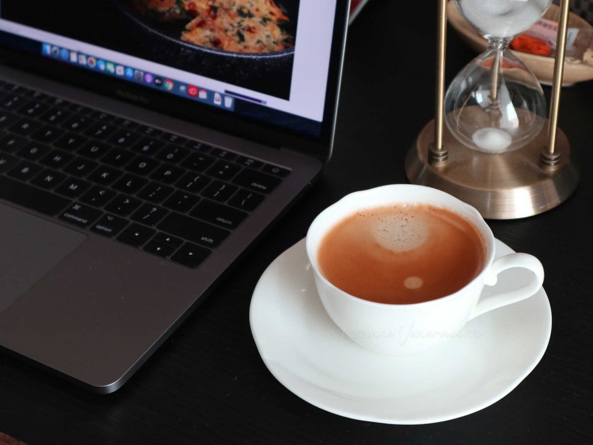 Cup of coffee beside Macbook Pro