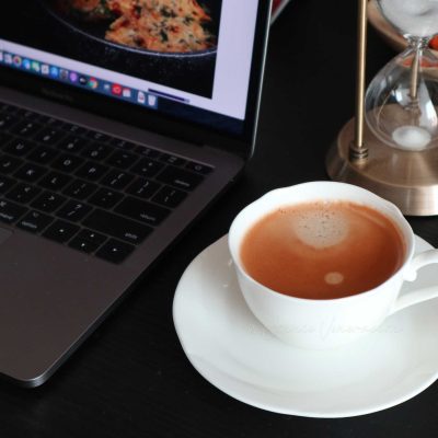 Cup of coffee beside Macbook Pro