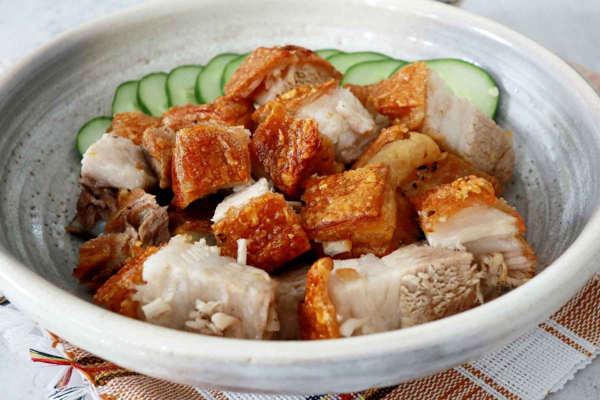 Air fryer lechon kawali (crispy pork belly) with cucumber slices in serving bowl