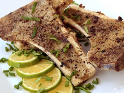 Grilled bone marrow sprinkled with mint and served with lemon slices