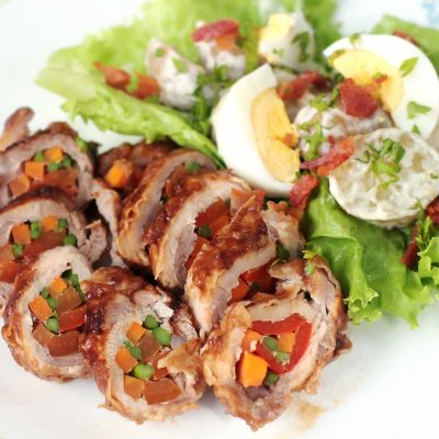 Stuffed and rolled pork loin with salad on plate