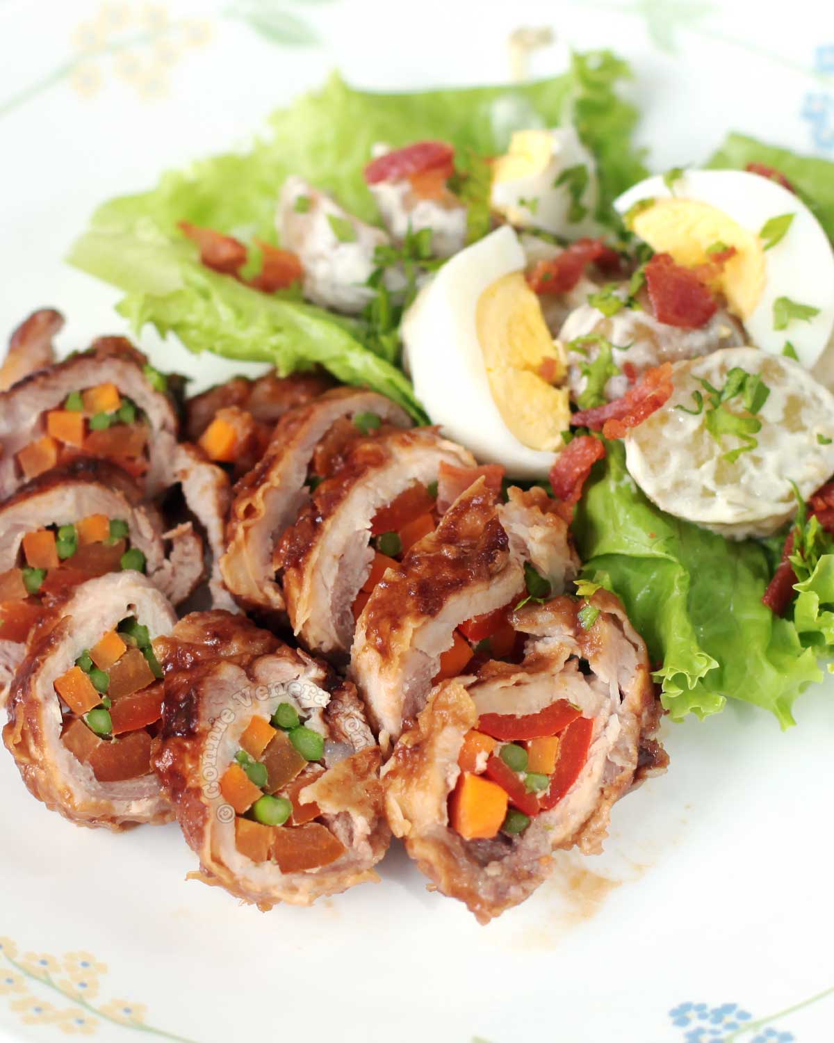 Stuffed and rolled pork loin with salad on plate