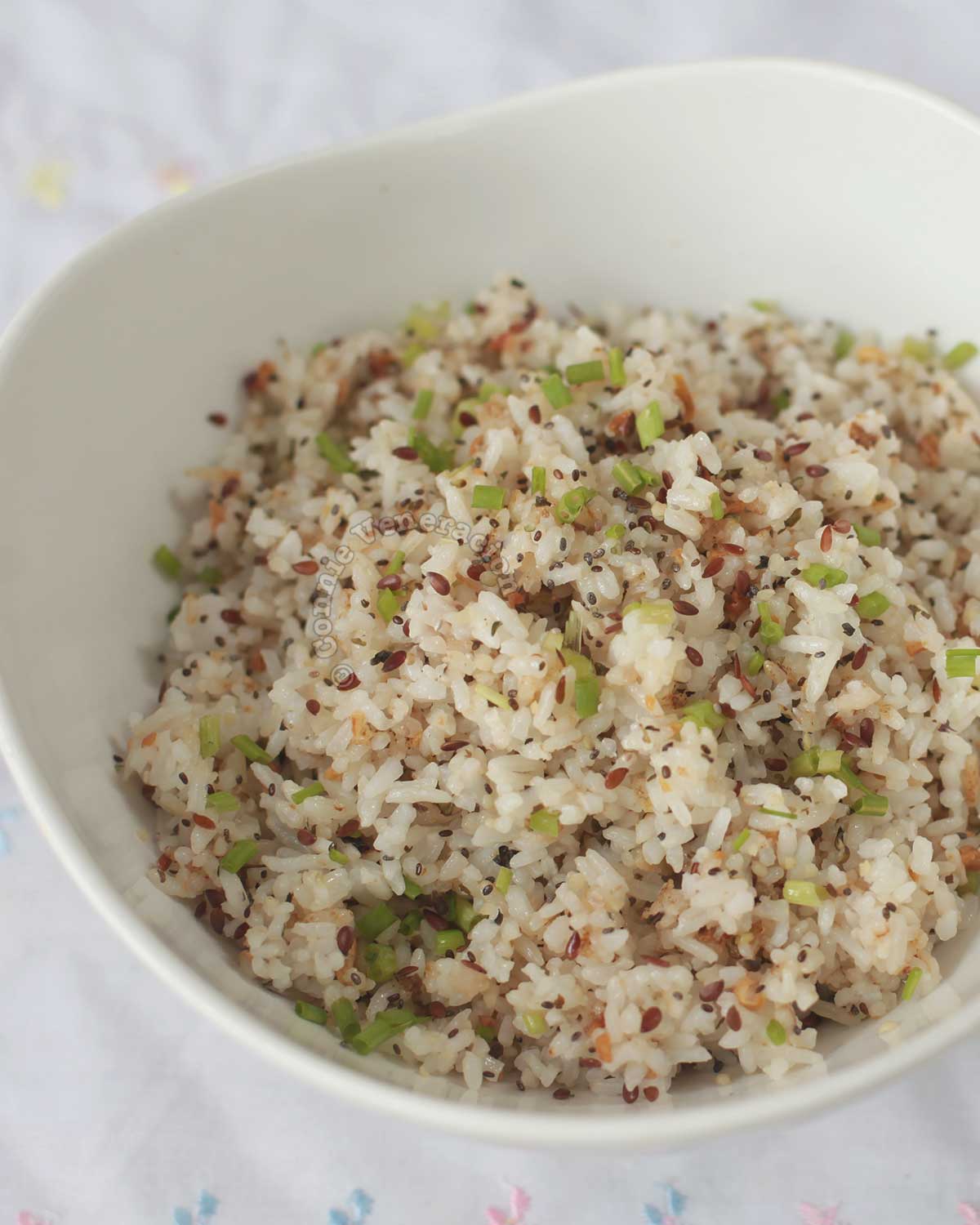 Fried rice with herbs and seeds in white serving bowl