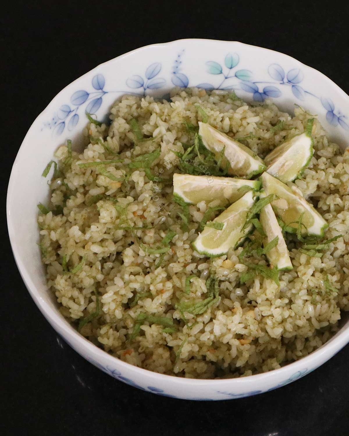Pesto rice garnished with mint leaves and lime wedges