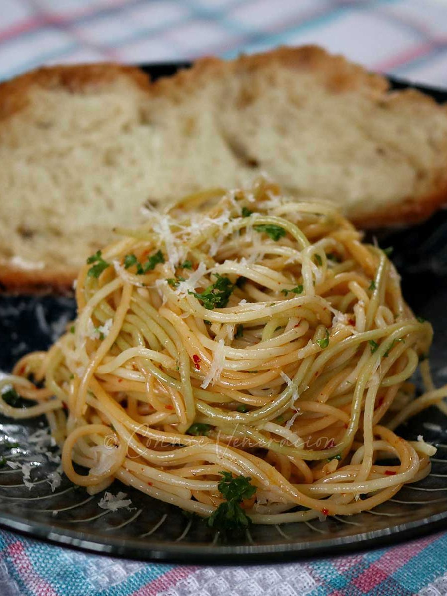 Spaghettini aglio e olio with bread in shallow bowl