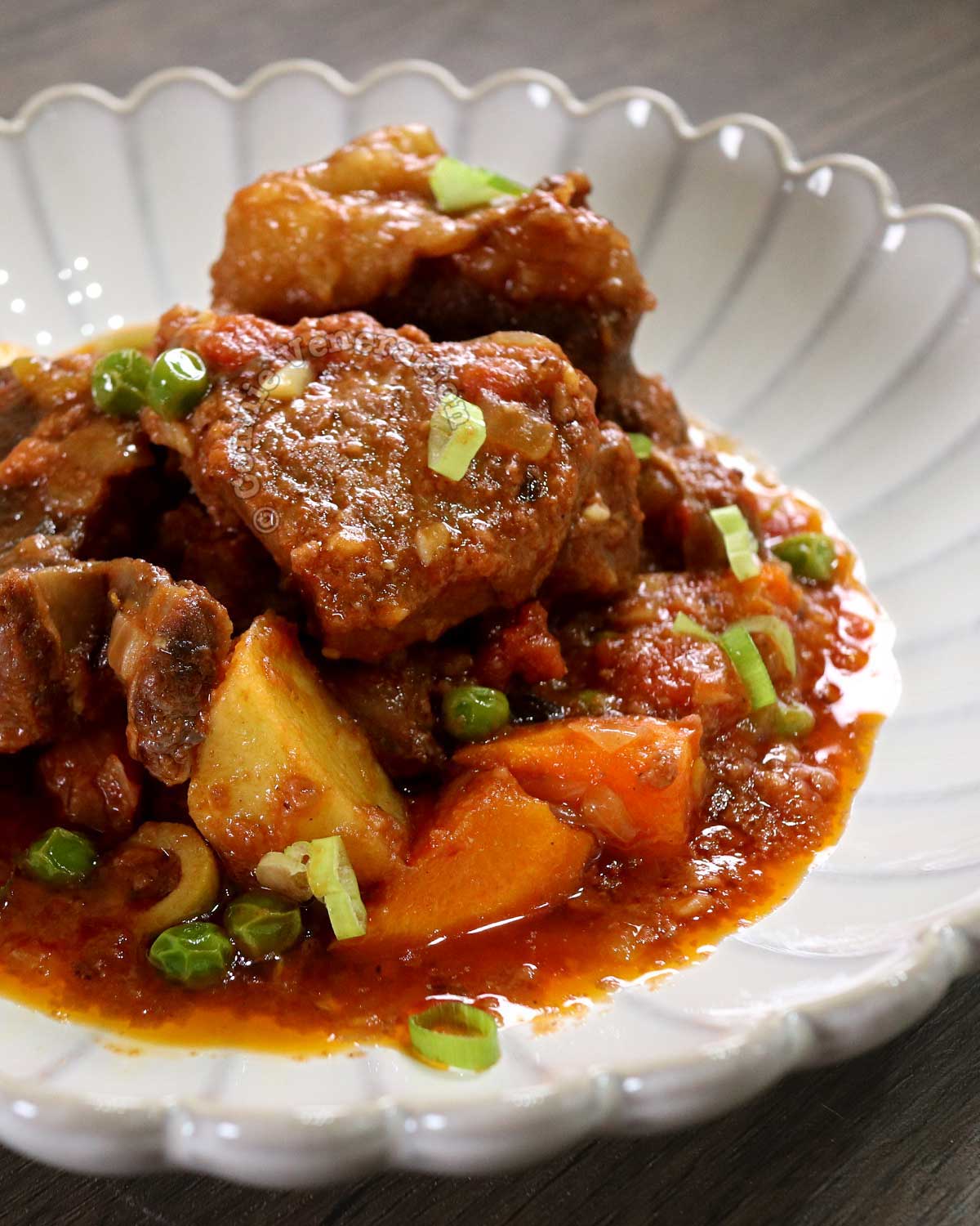 Filipino beef kaldereta in white shallow bowl