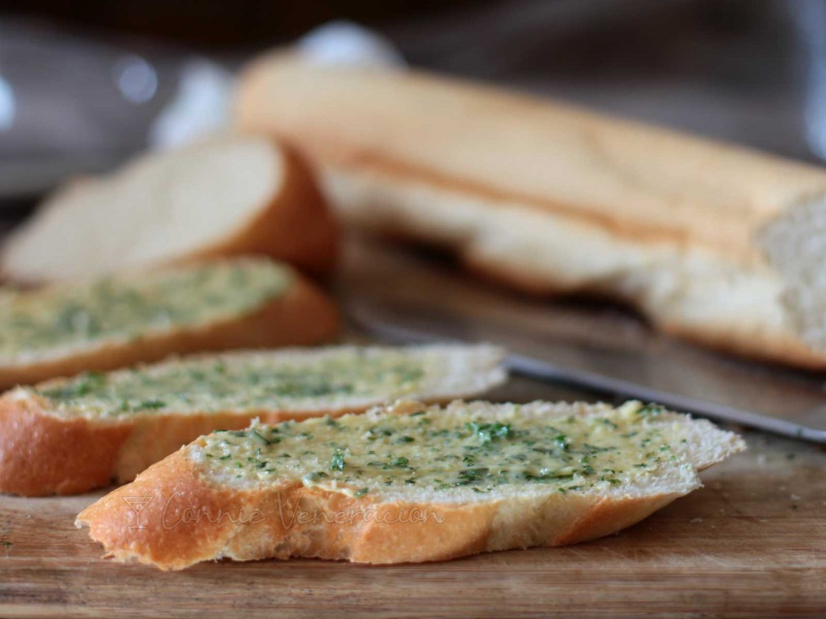 Baguette slices spread with softened butter, herbs and garlic