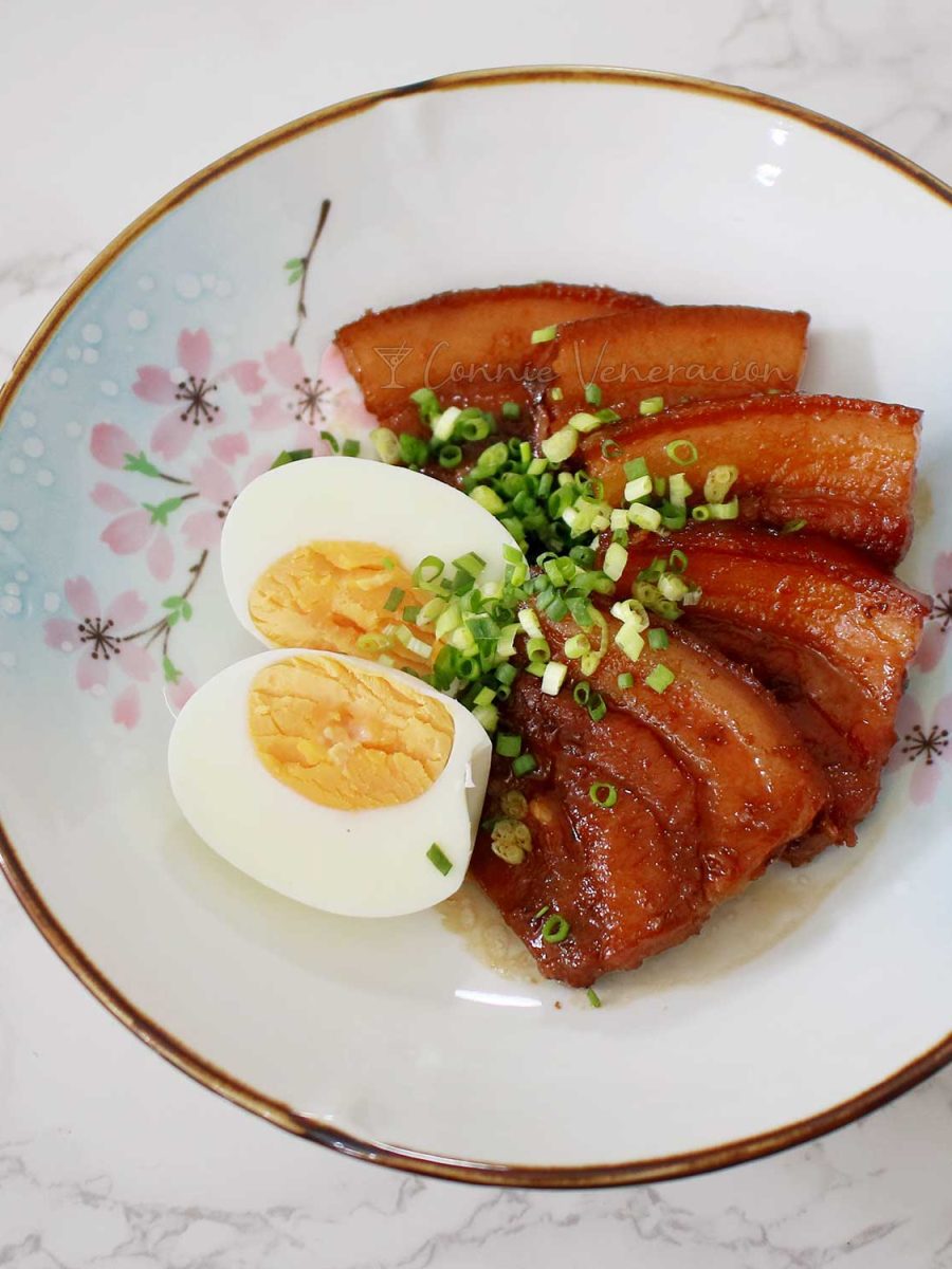 Japanese braised pork belly (buta no kakuni) and halved hard boiled egg garnished with scallions