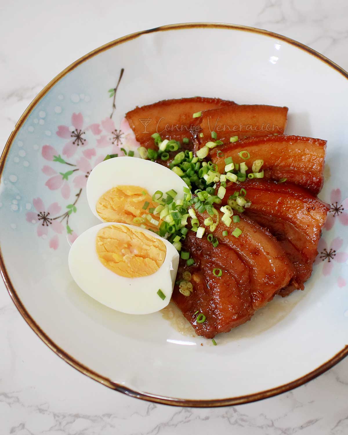 Japanese braised pork belly (buta no kakuni) and halved hard boiled egg garnished with scallions