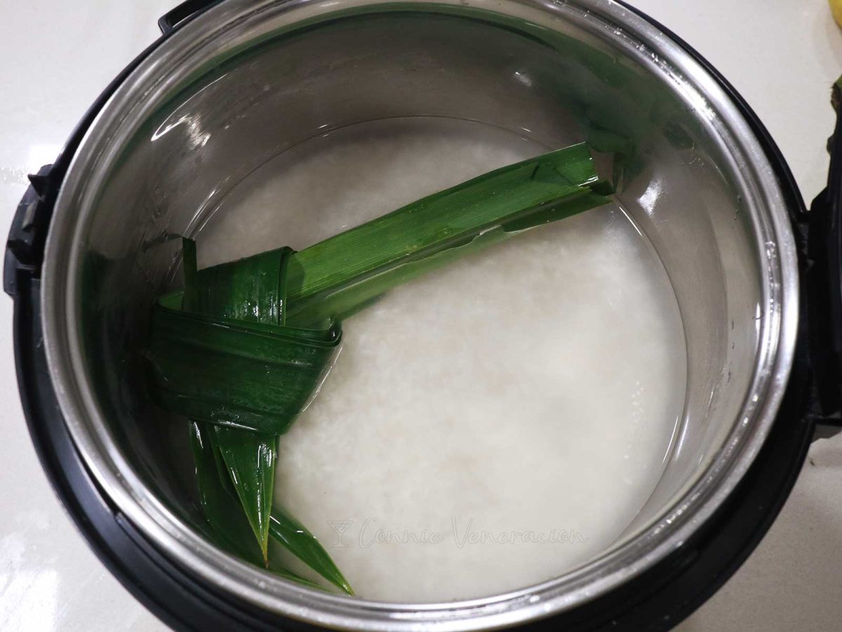 Rice, water and pandan leaf in rice cooker