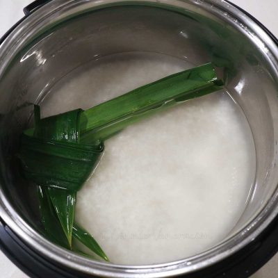 Rice, water and pandan leaf in rice cooker