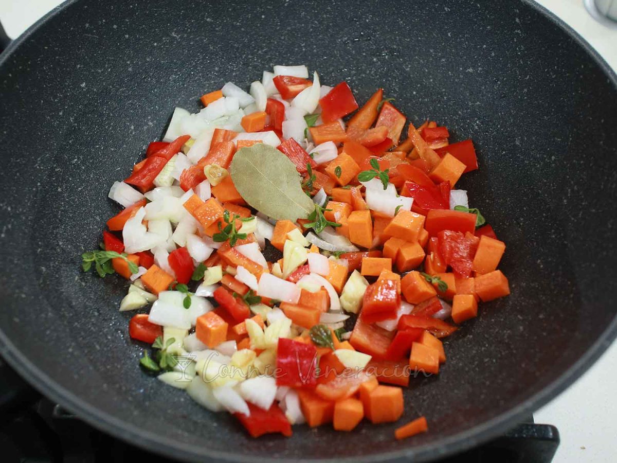 Onion, garlic, bell pepper, carrot, bay leaf and oregano in pan