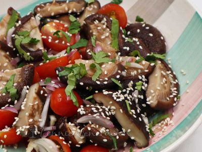 Shiitake and cherry tomato salad sprinkled with toasted sesame seeds and scallions