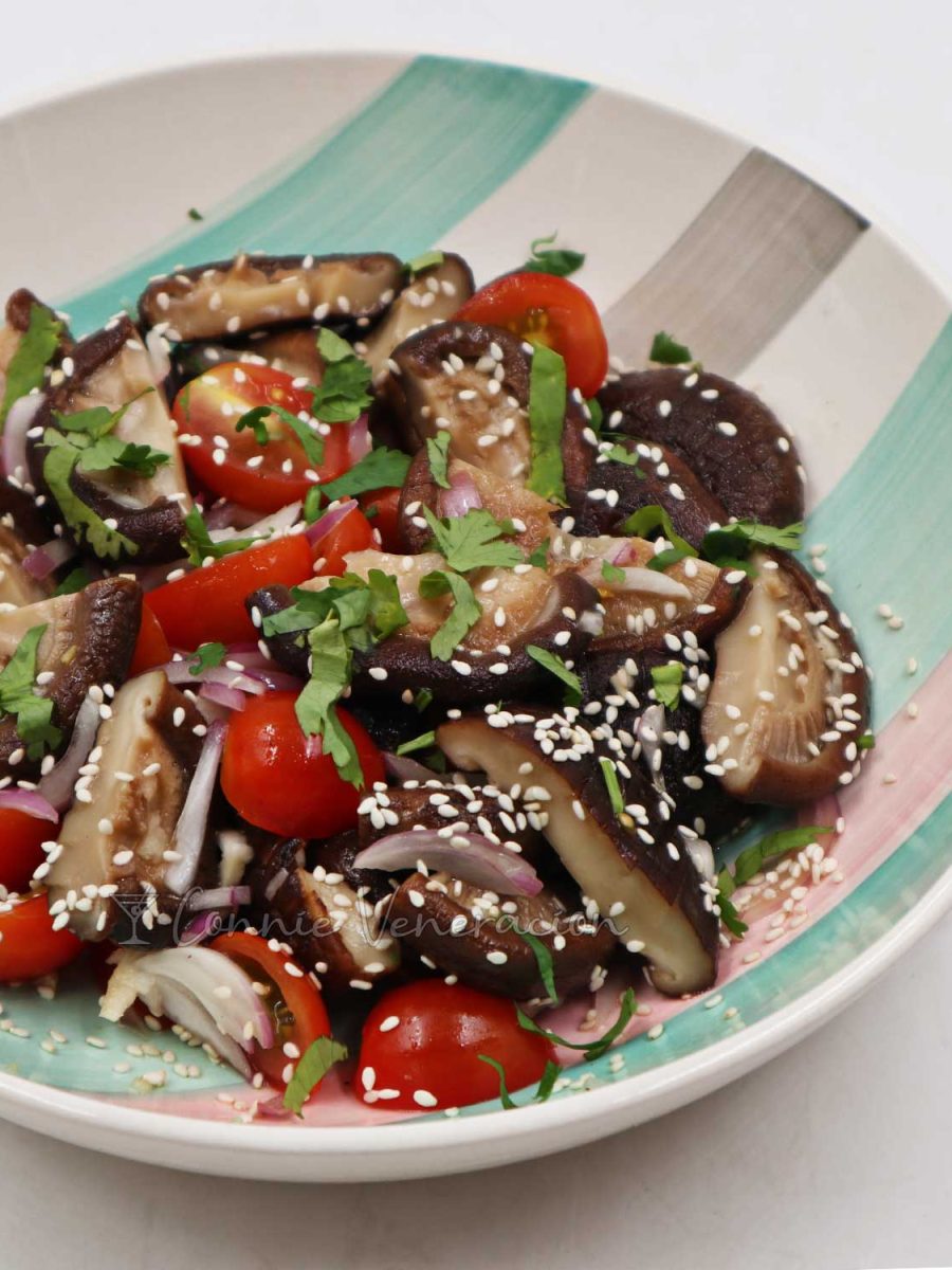 Shiitake and cherry tomato salad sprinkled with toasted sesame seeds and scallions