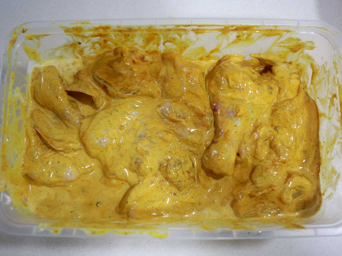 Cut-up chicken marinating in seasonings, spices and sour cream