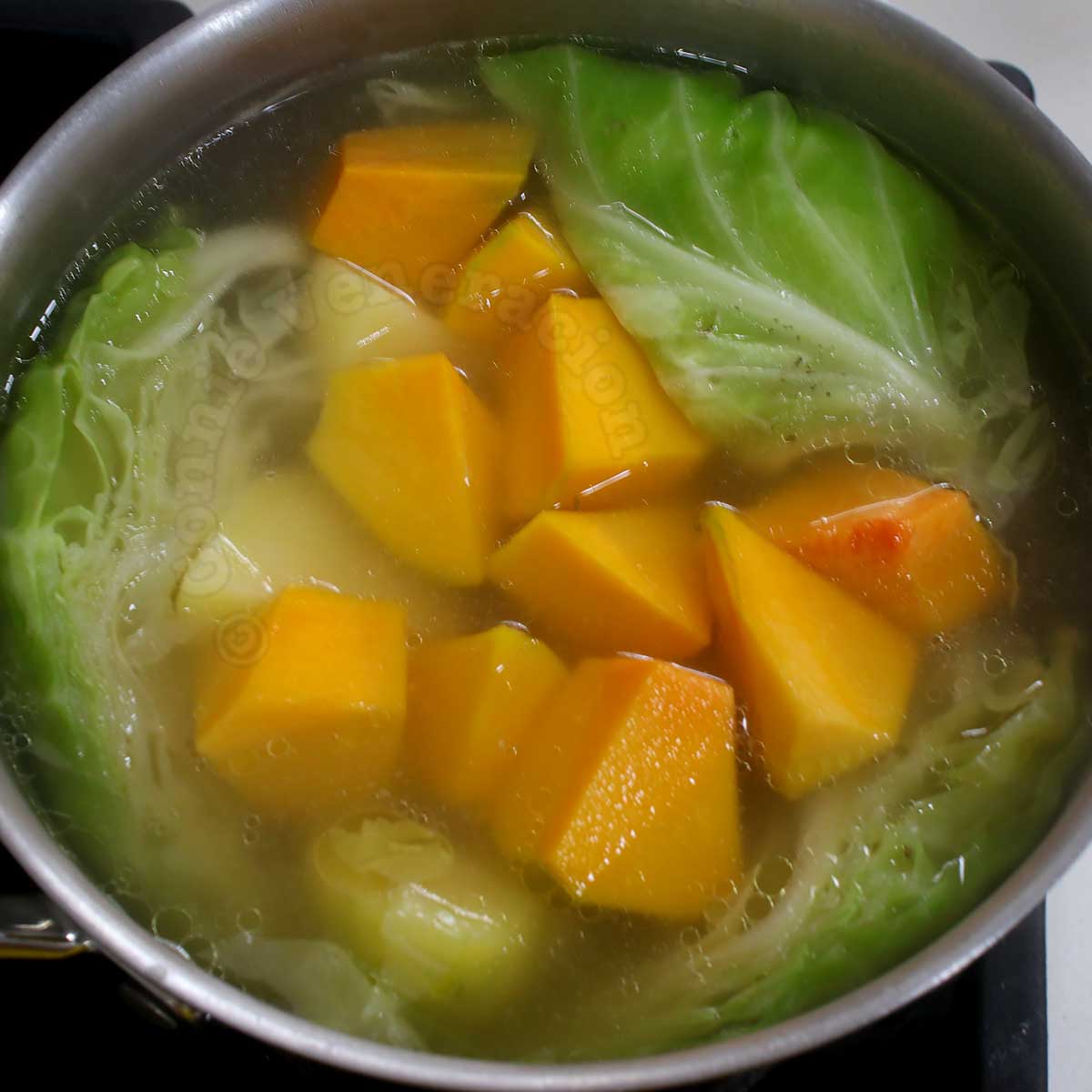 Boiling squash, potatoes and cabbage in chicken broth