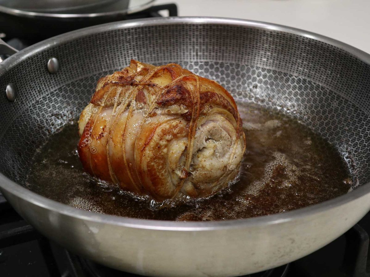 Browning rolled pork belly in oil to make chashu