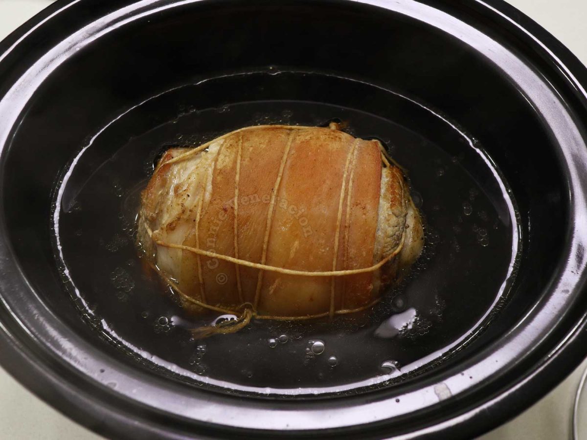 Braising rolled pork belly in slow cooker to make chashu