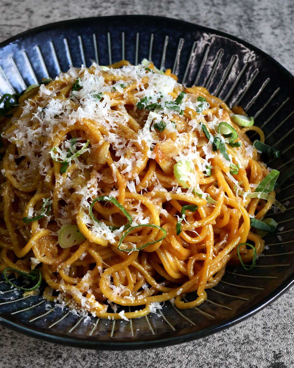 San Franciso-style garlic noodles topped with grated Pecorino and scallions
