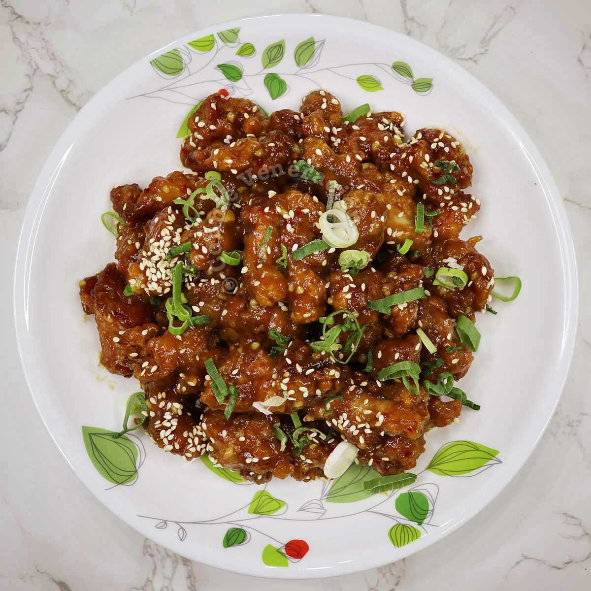 General Tso's chicken garnished with scallions and sesame seeds