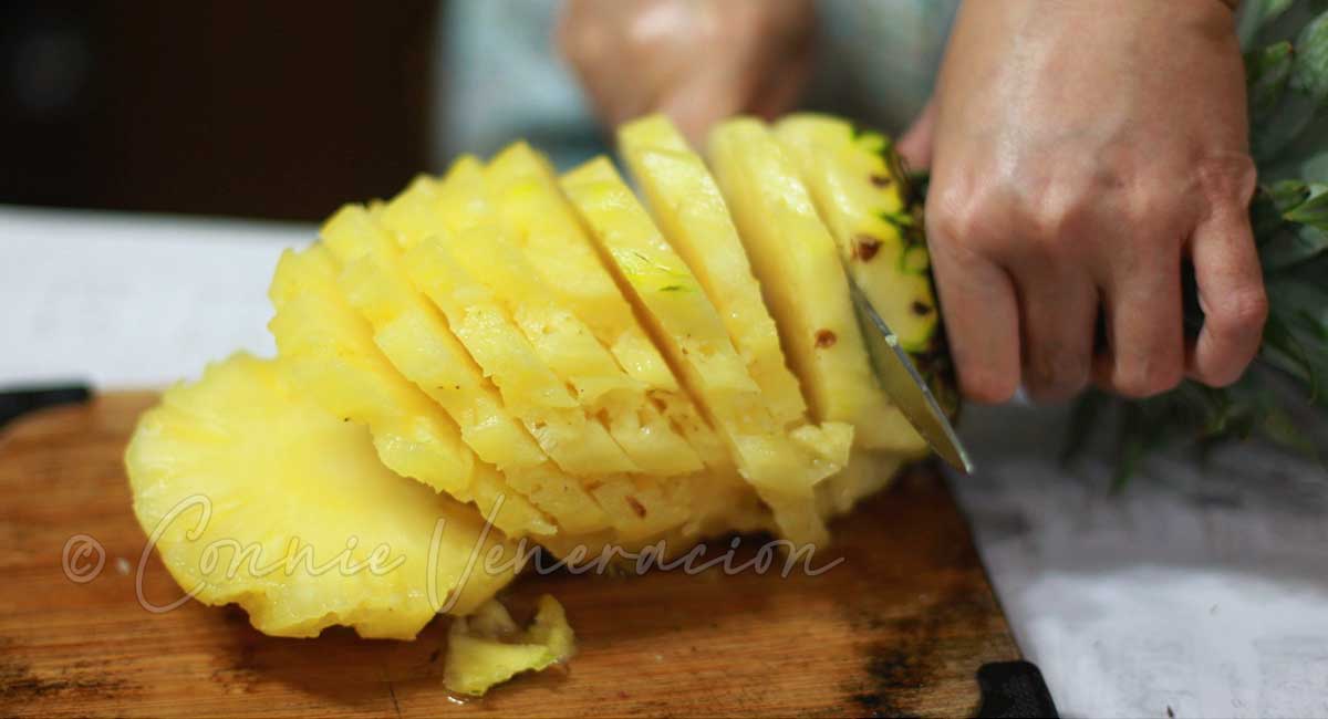 Slicing a skinned pineapple