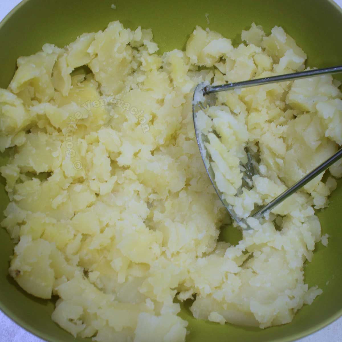 Coarsely mashed potatoes in mixing bowl
