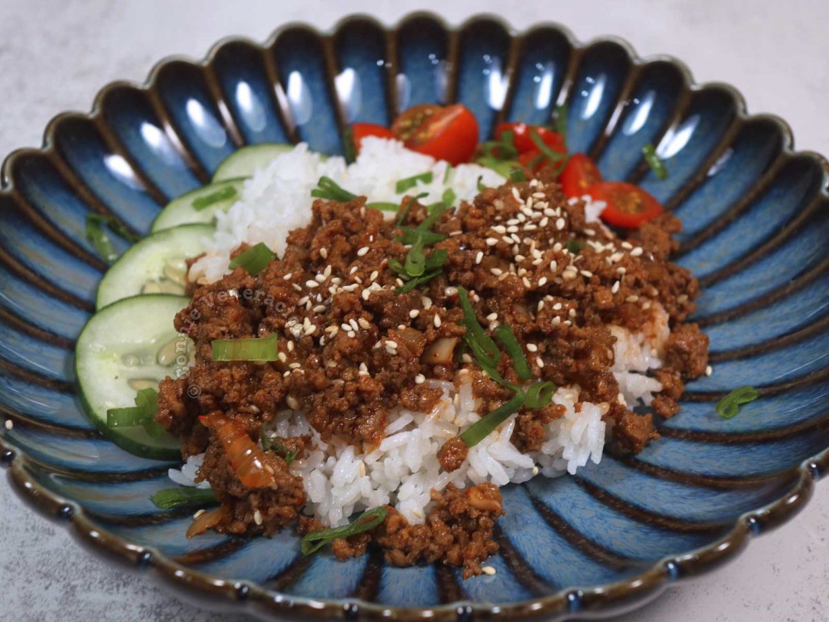 Korean-style ground beef rice bowl with cucumber, tomatoes, scallions and sesame seeds