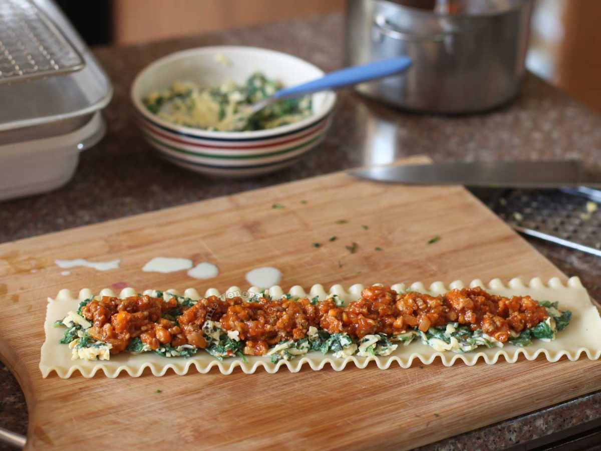 Meat, spinach and cheese spread on lasagna noodle
