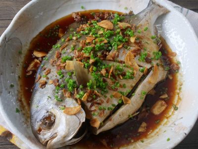 Steamed pompano with ginger sauce garnished with scallions, fried garlic and shallots