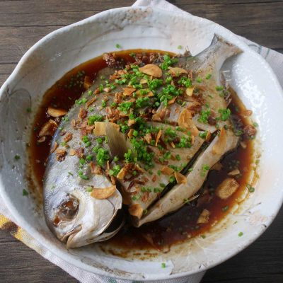 Steamed pompano with ginger sauce garnished with scallions, fried garlic and shallots