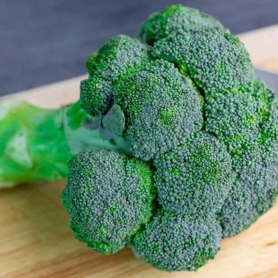 A head of broccoli on chopping board
