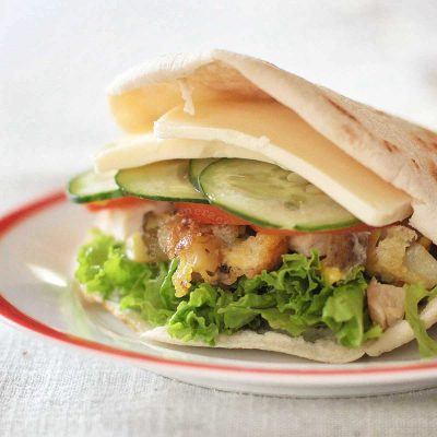 Pita pocket stuffed with chicken, eggs, vegetables and cheese