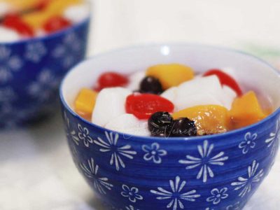 Almond jelly, peaches, cherries and blueberries in blue bowls